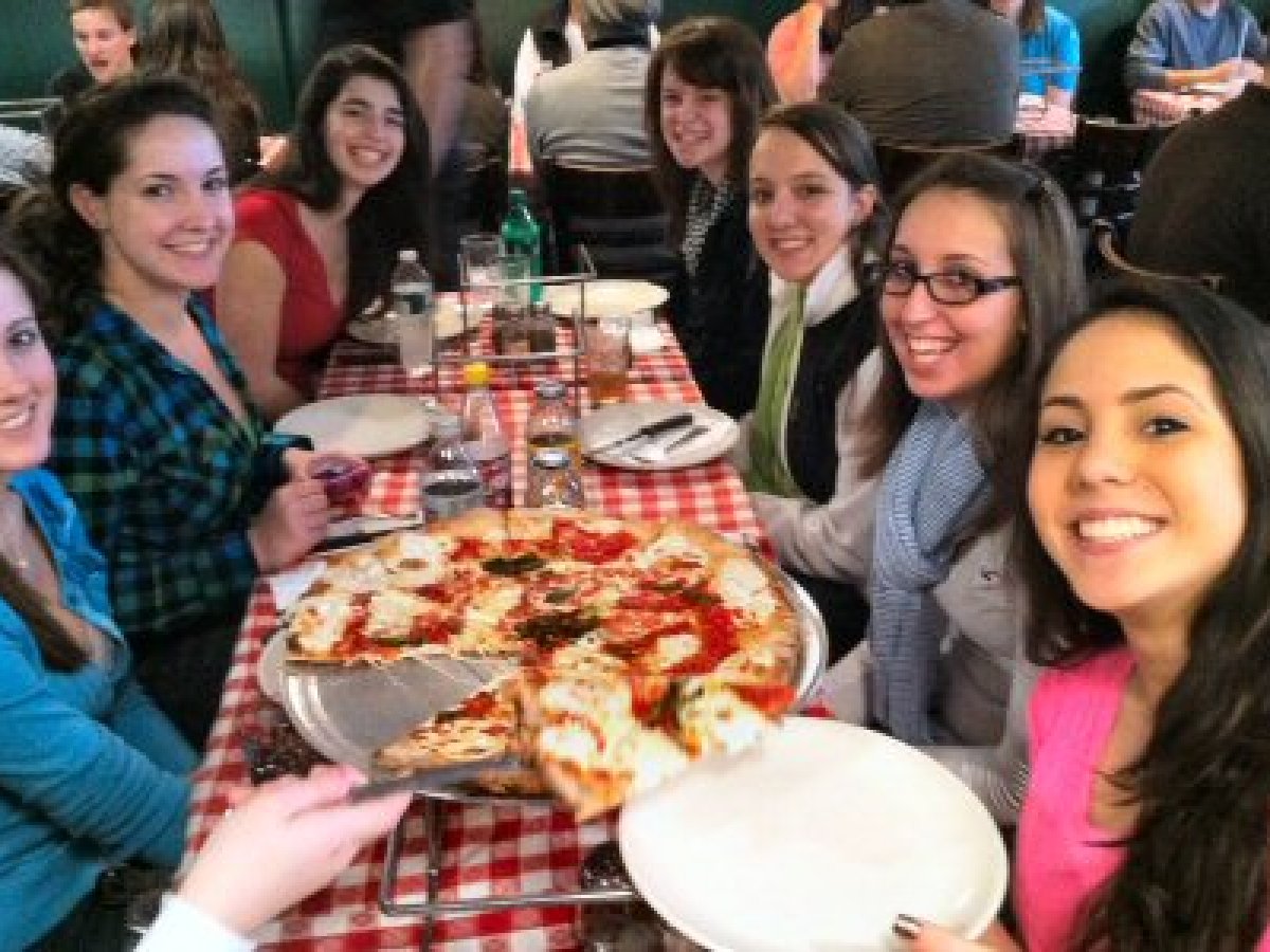 Rebecca Makkai et al. sitting at a table eating pizza